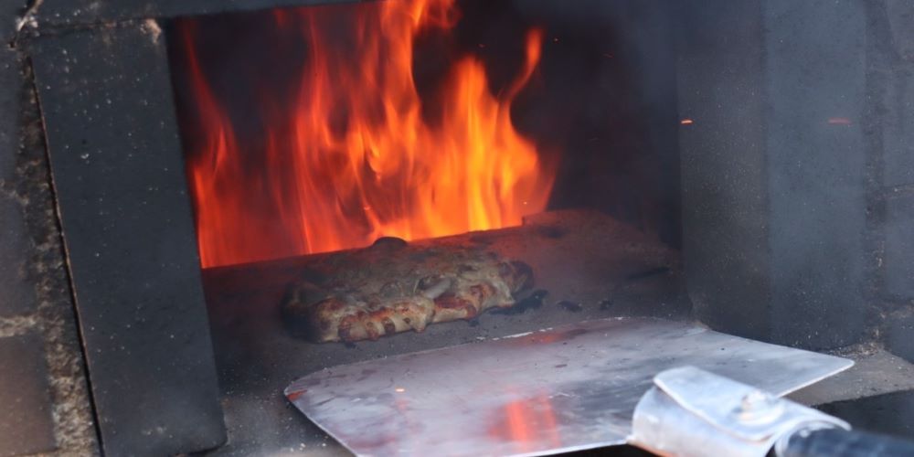 ピザ窯でピザを焼いている写真